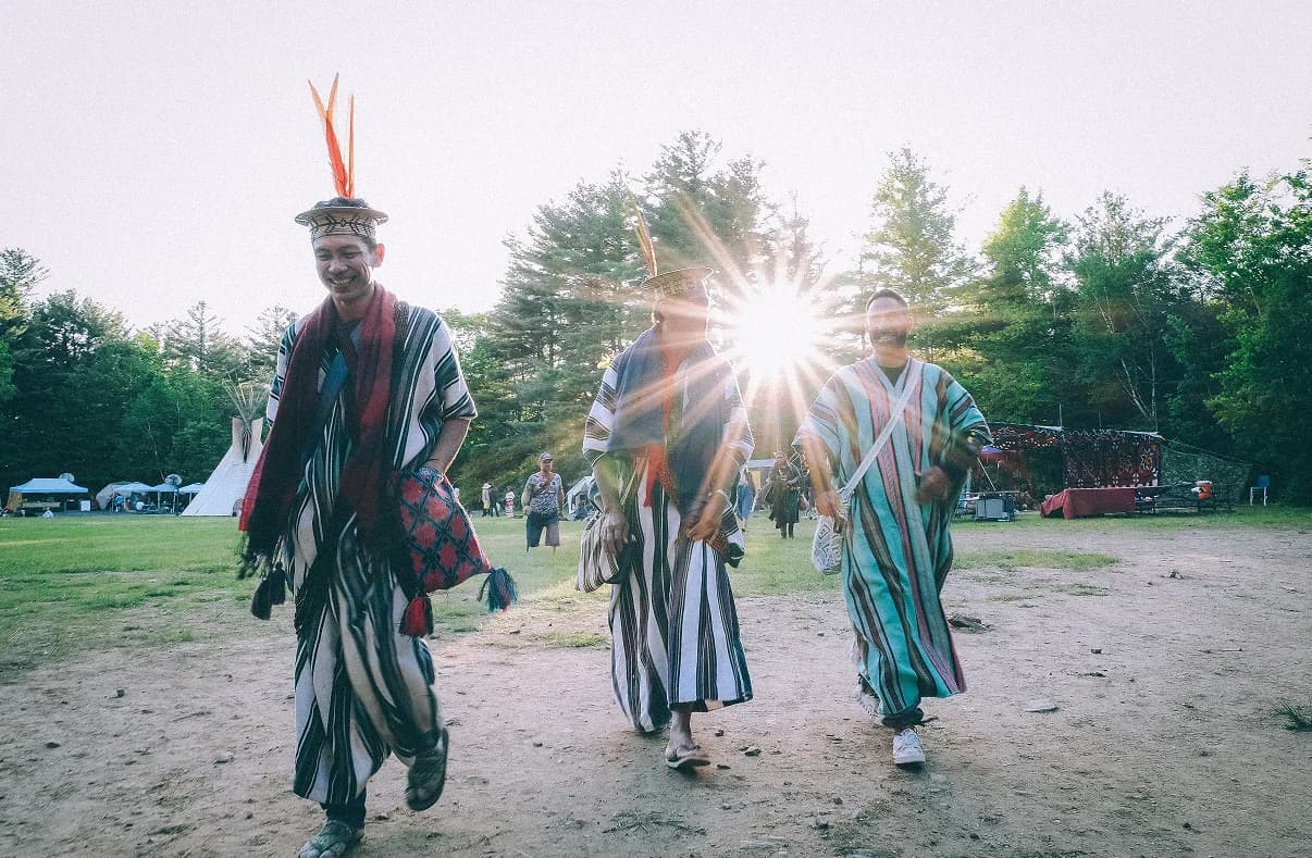 Ceremonial procession in open field at sunset